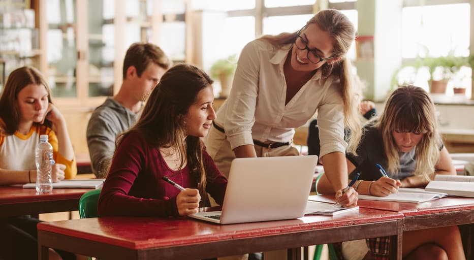 Adjunct professor helping student in the classroom