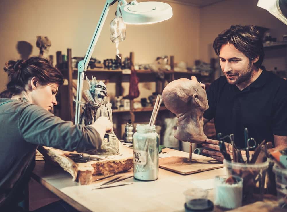 Below the line film crew creating movie monsters in their workshop