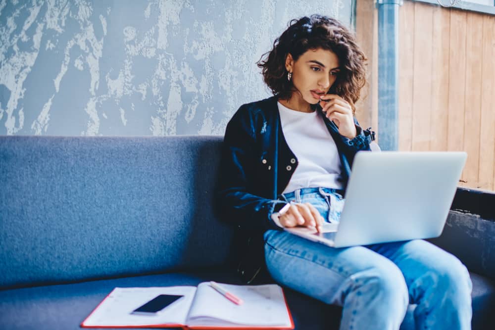 Young female screenwriter using screenwriting software on her laptop
