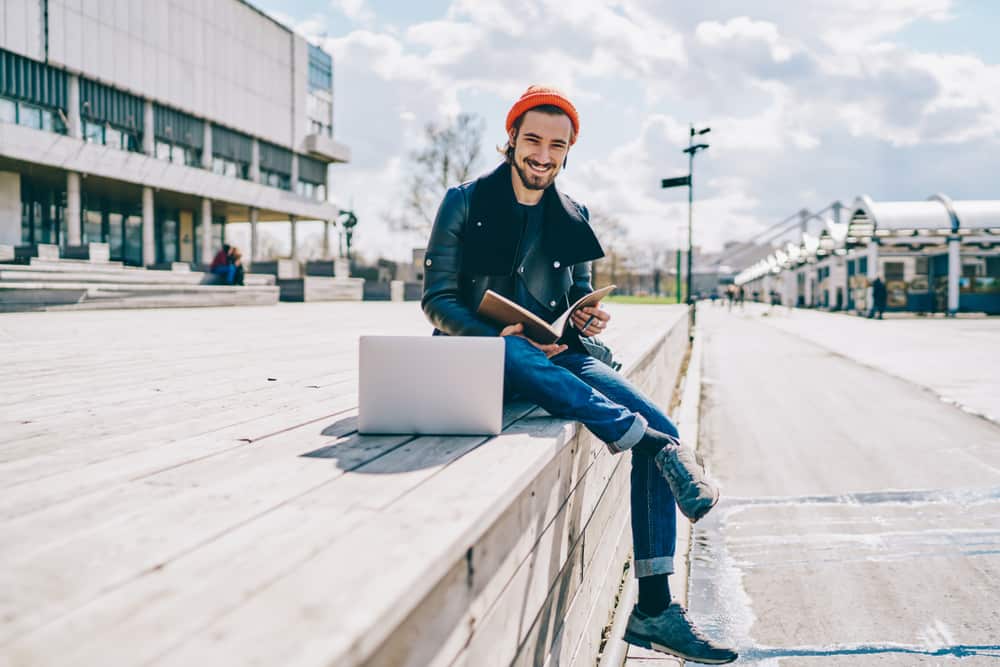 Film major reading a book on urban college campus